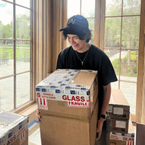 man holding box labeled glass: fragile